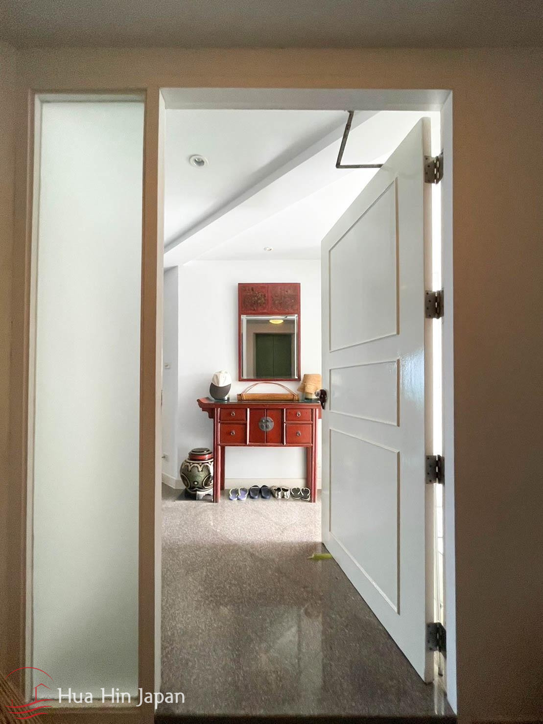 Bright apartment hallway leading to bedroom and living areas