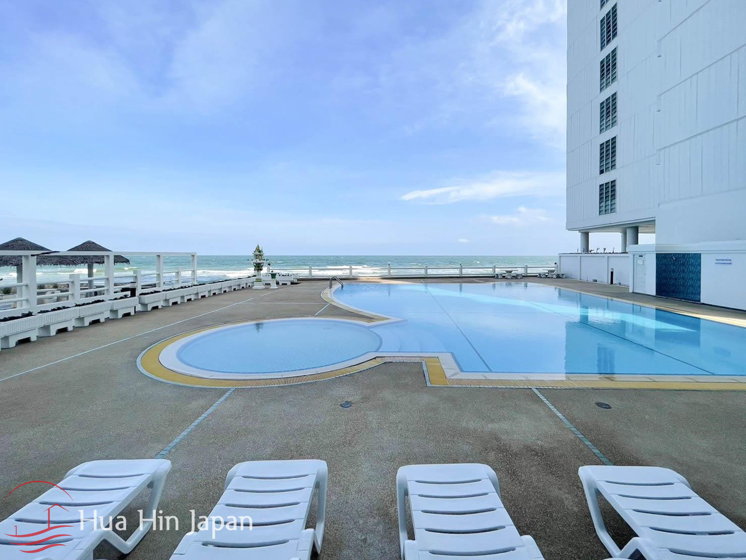 Outdoor swimming pool overlooking the ocean with sun loungers