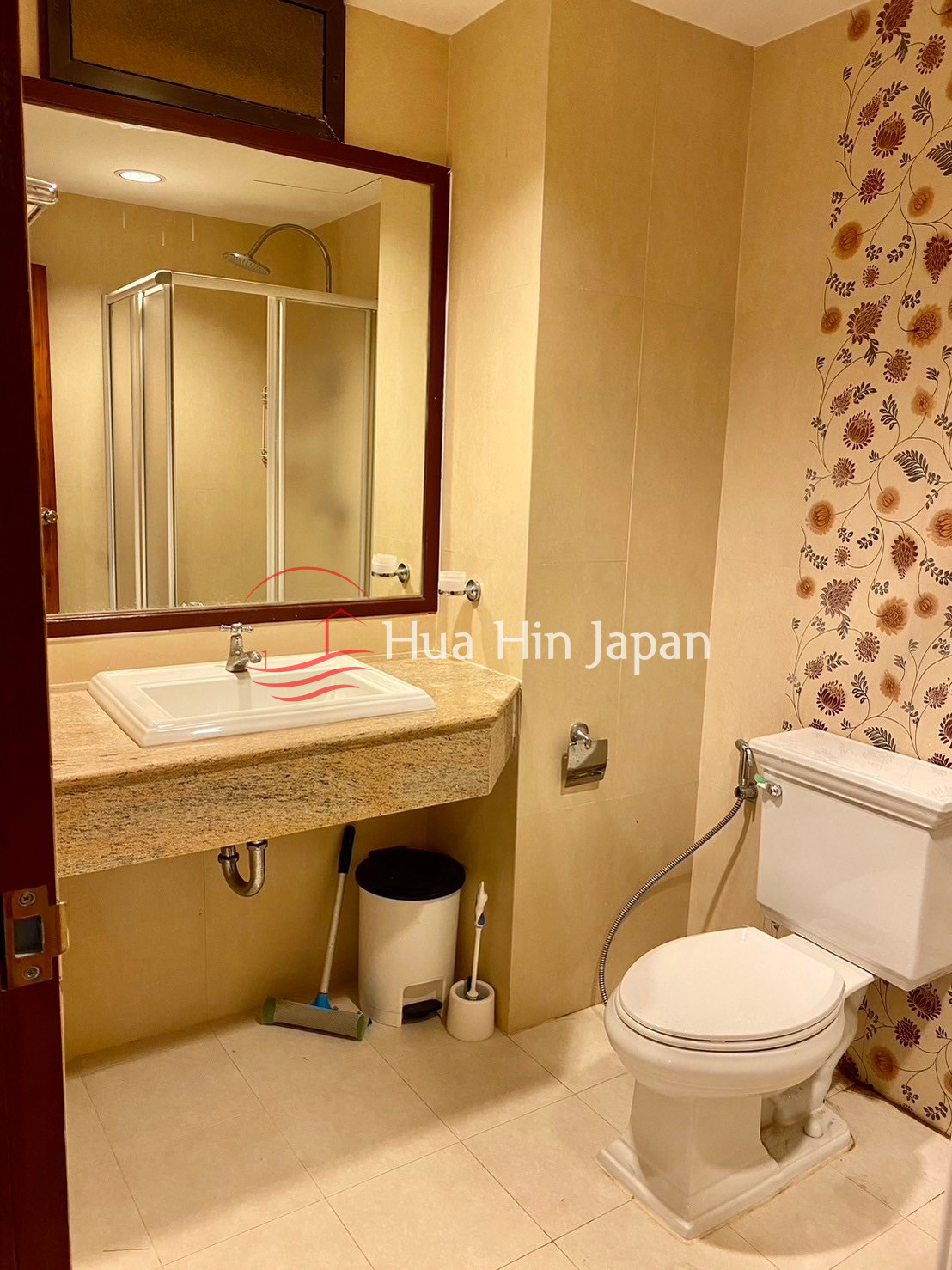 Modern bathroom with wooden vanity, mirror, bathtub, and patterned wall tiles