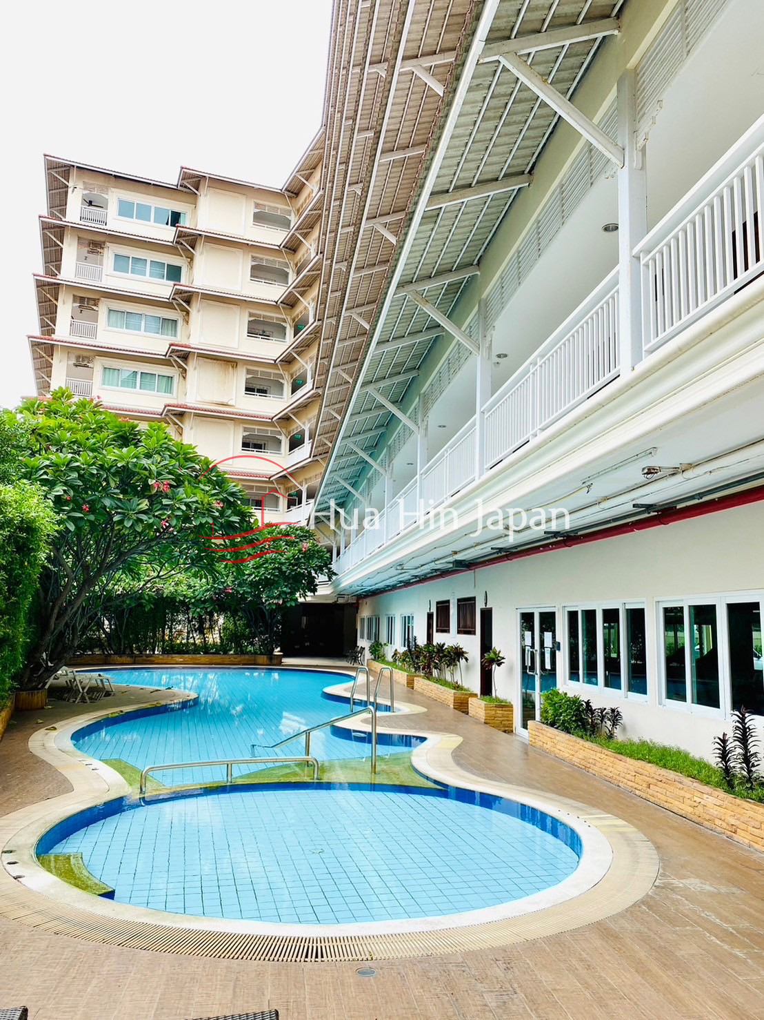 Residential complex with swimming pool, landscaped garden, and multi-story buildings
