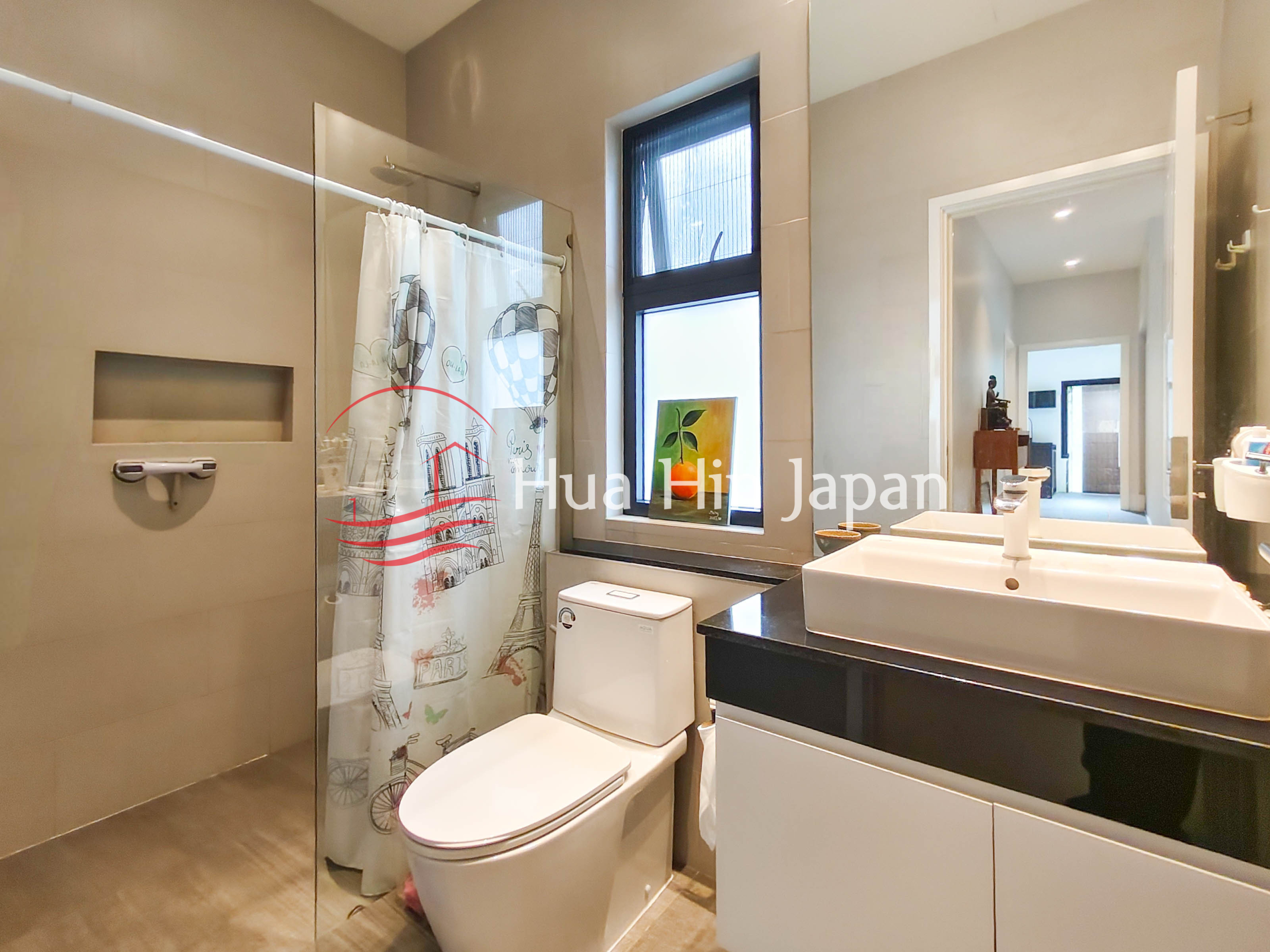 Modern bathroom with glass shower enclosure, white toilet, double sink vanity and window