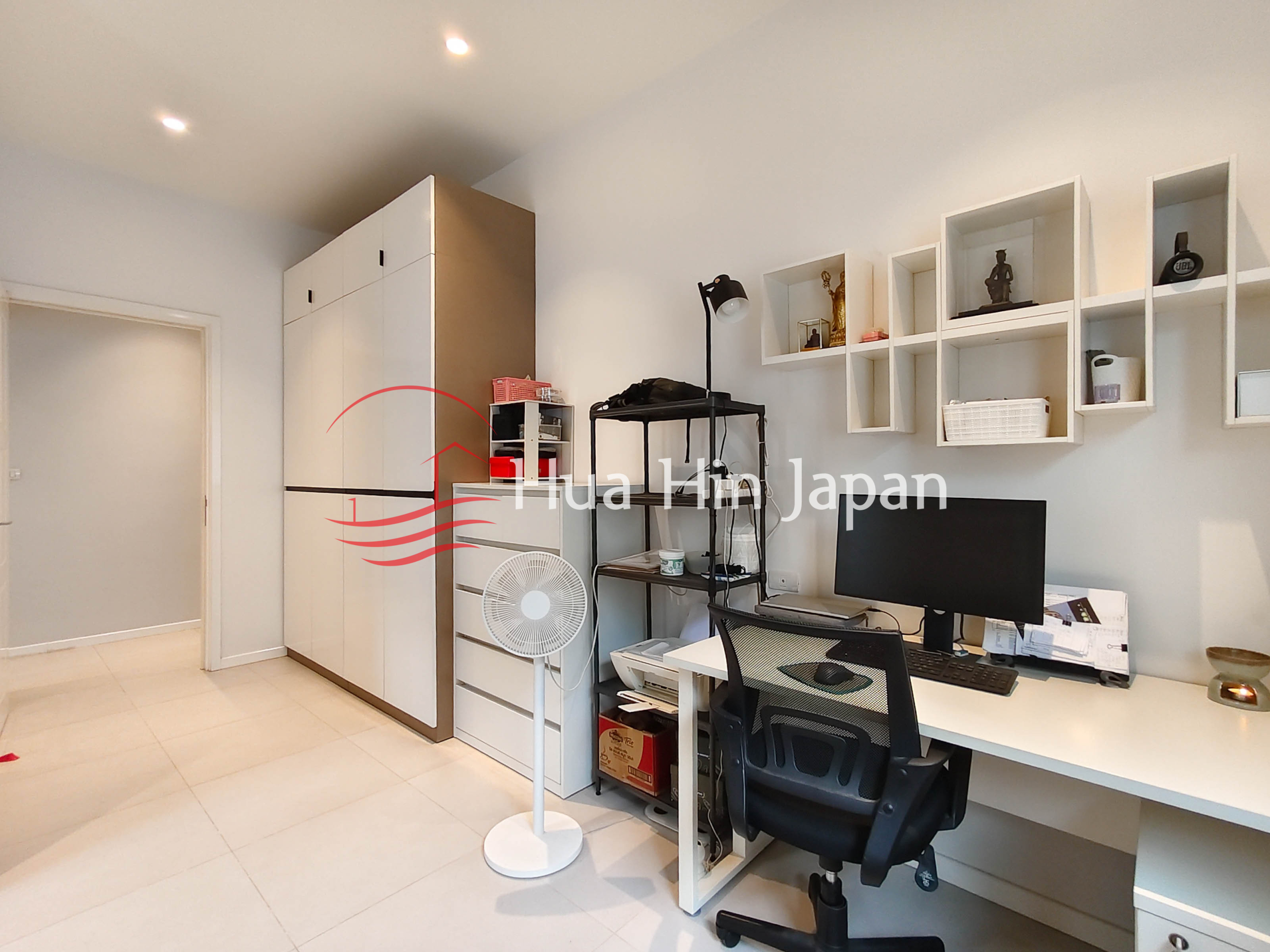 Modern home office with desk, computer, wardrobe, shelving and office chair