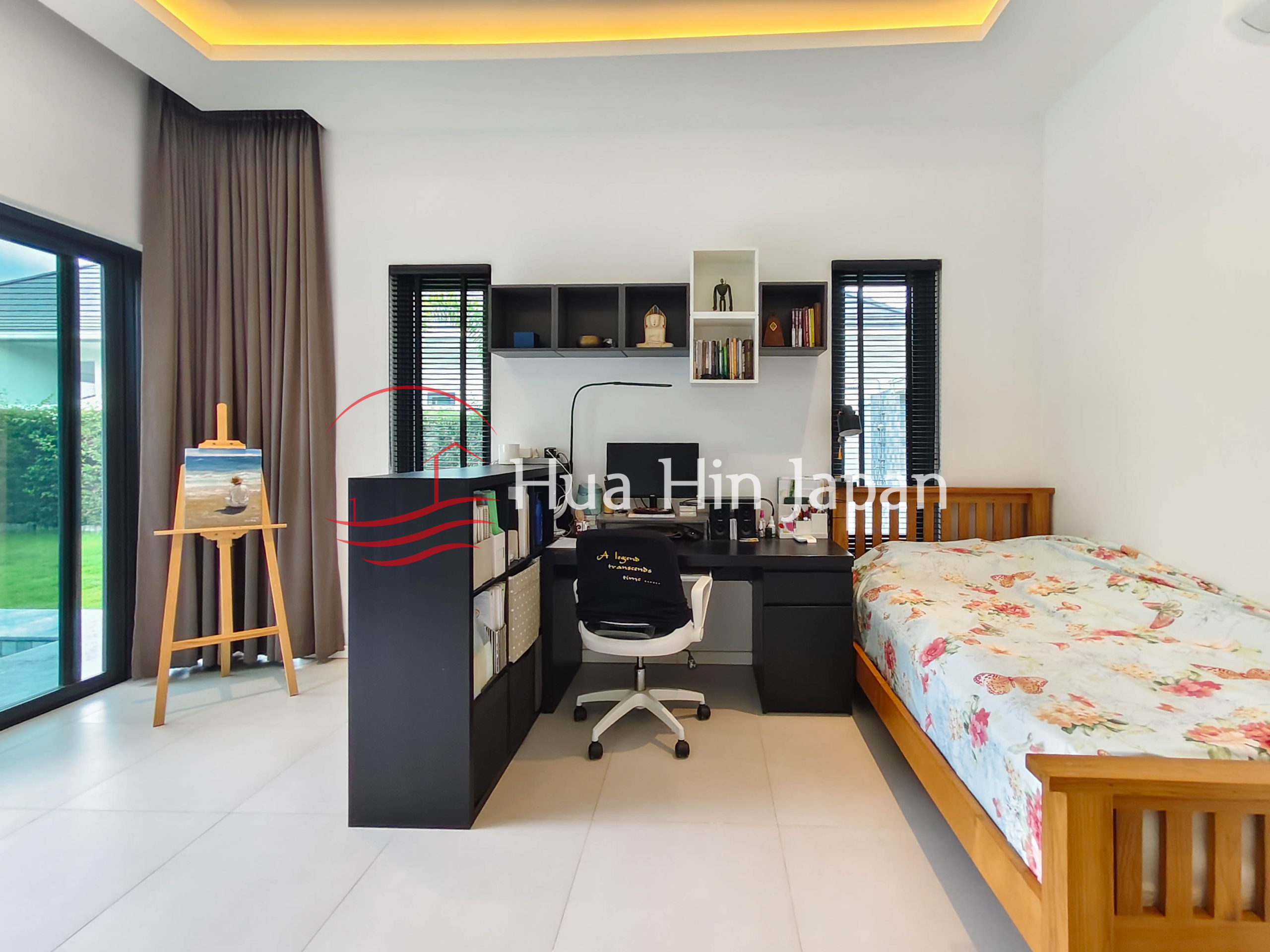 Bright modern bedroom with wooden bed, home office desk, bookshelf and large glass doors