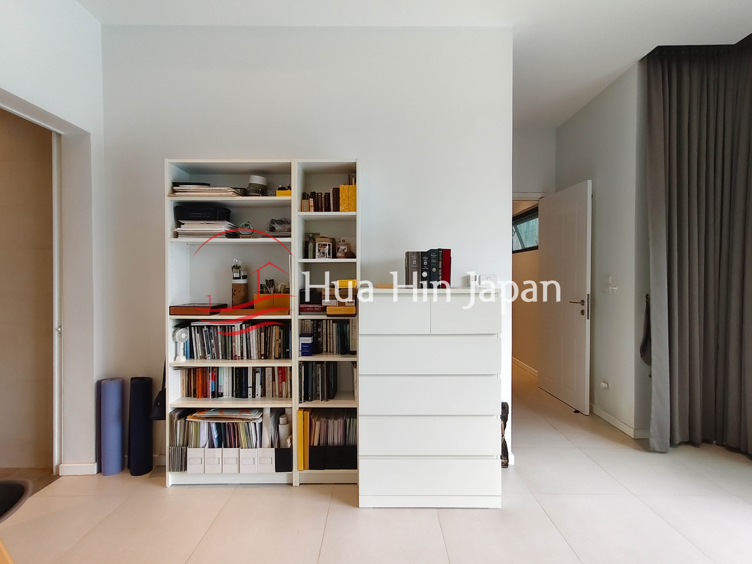 Modern interior with built-in bookshelf, storage drawers and hallway