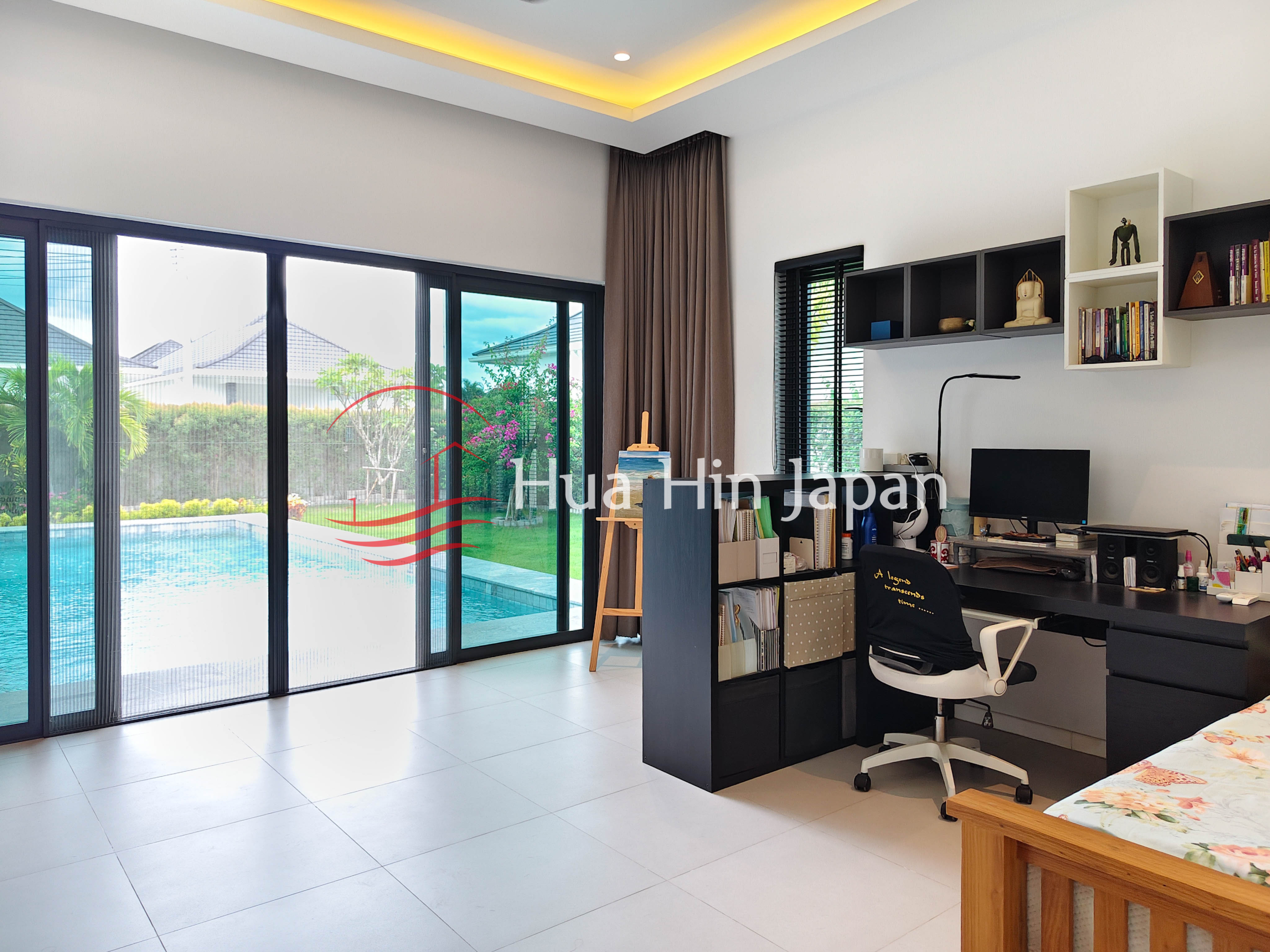Modern bedroom with home office, large glass doors and pool view