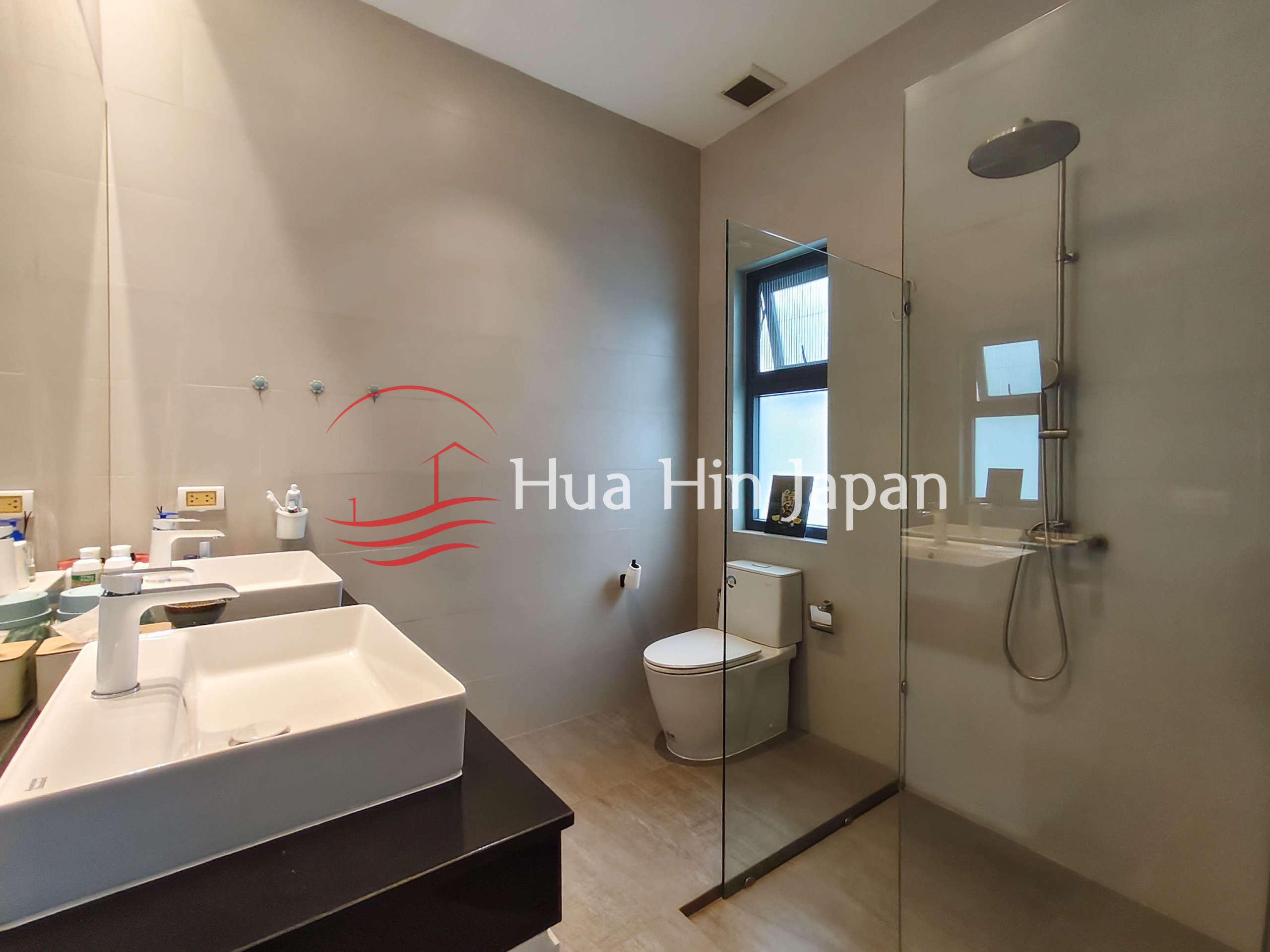 Modern bathroom with double vanity, glass shower and toilet