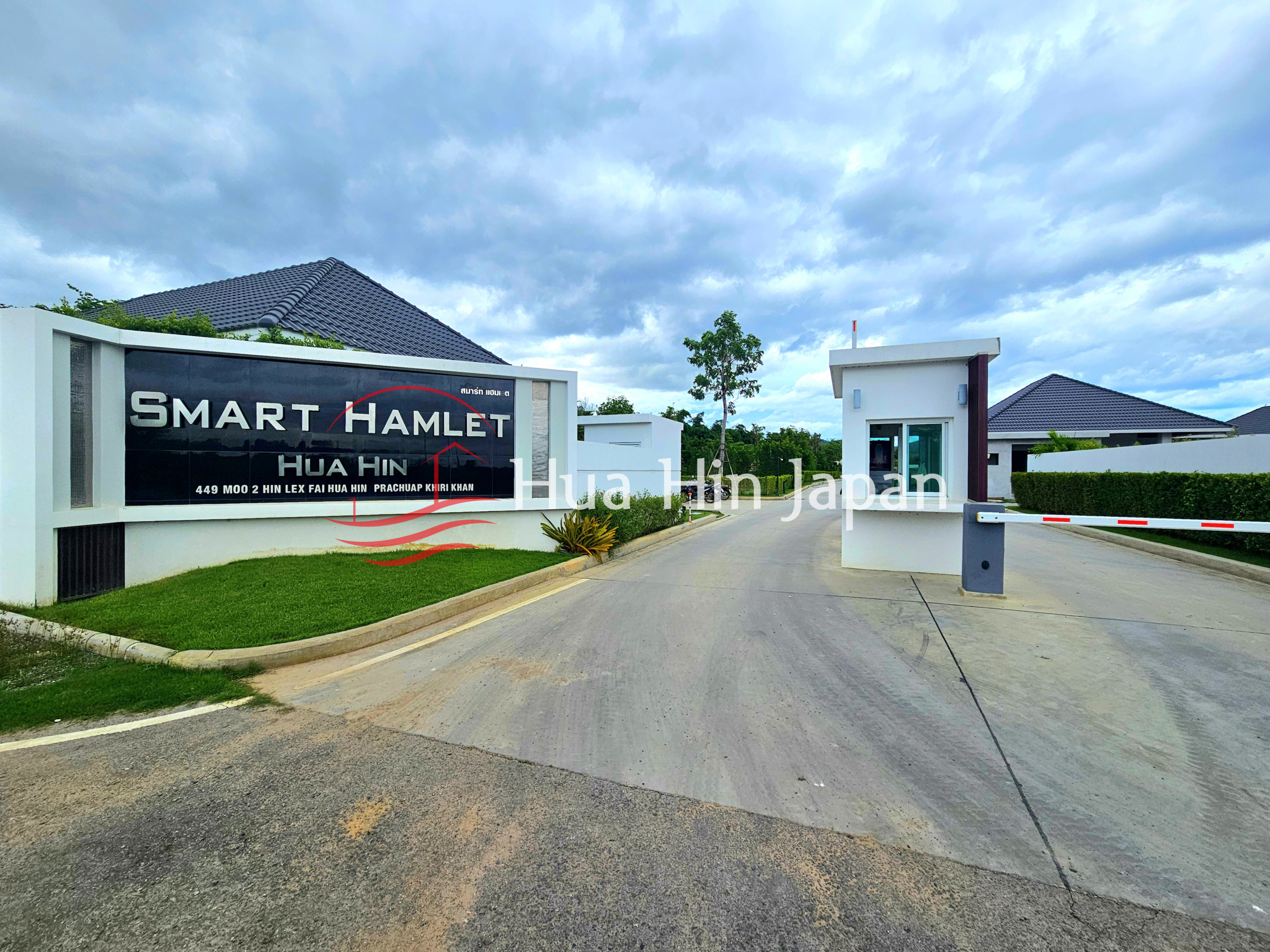 Gated entrance to Smart Hamlet Hua Hin residential community with security booth and landscaped grounds
