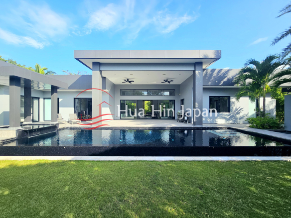 Modern luxury villa with a large private swimming pool, covered outdoor terrace, and tropical landscaping