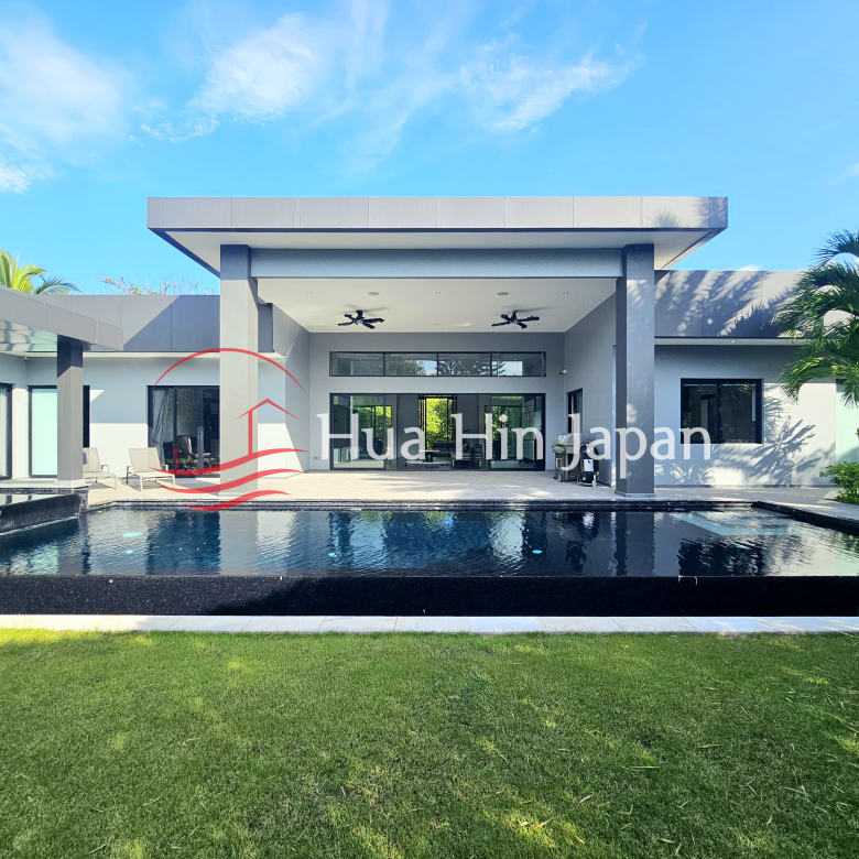 Modern luxury villa with a large private swimming pool, covered outdoor terrace, and tropical landscaping