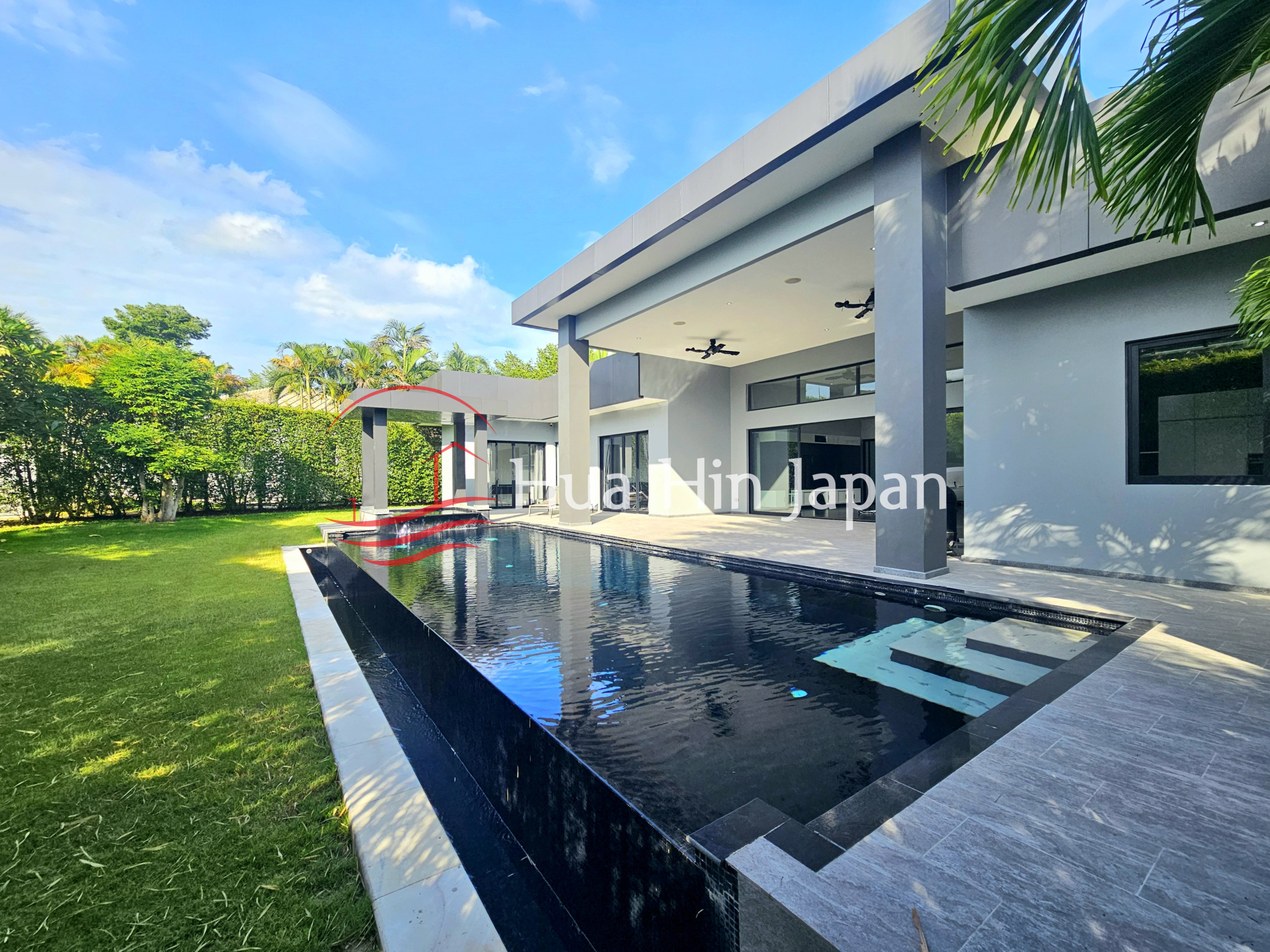 Modern luxury villa with a private swimming pool, covered terrace, and landscaped tropical garden