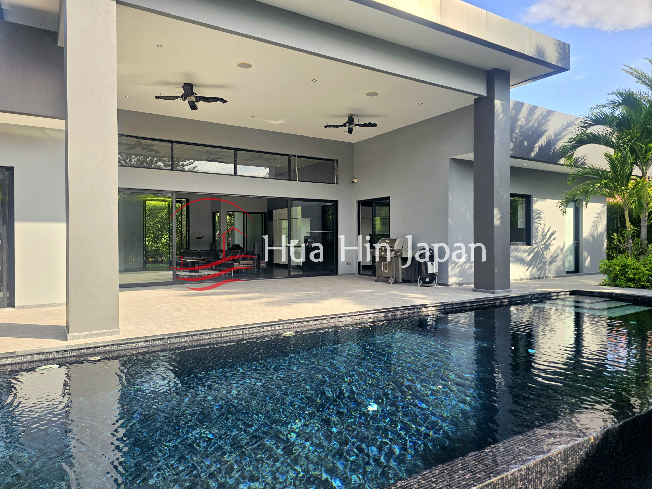 Modern villa with a private swimming pool, covered terrace, and large glass doors