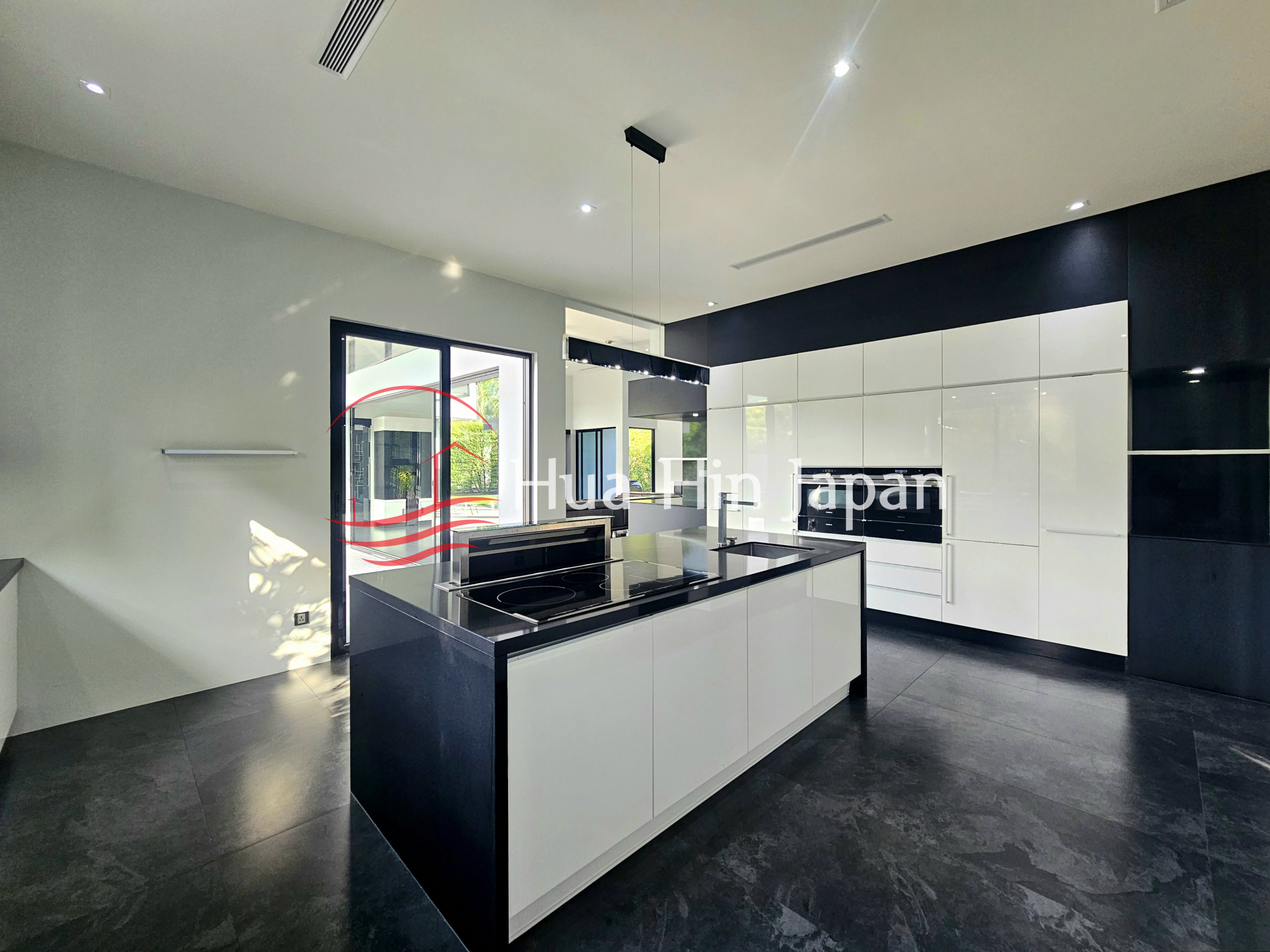 Spacious modern black and white kitchen with a large central island and built-in appliances