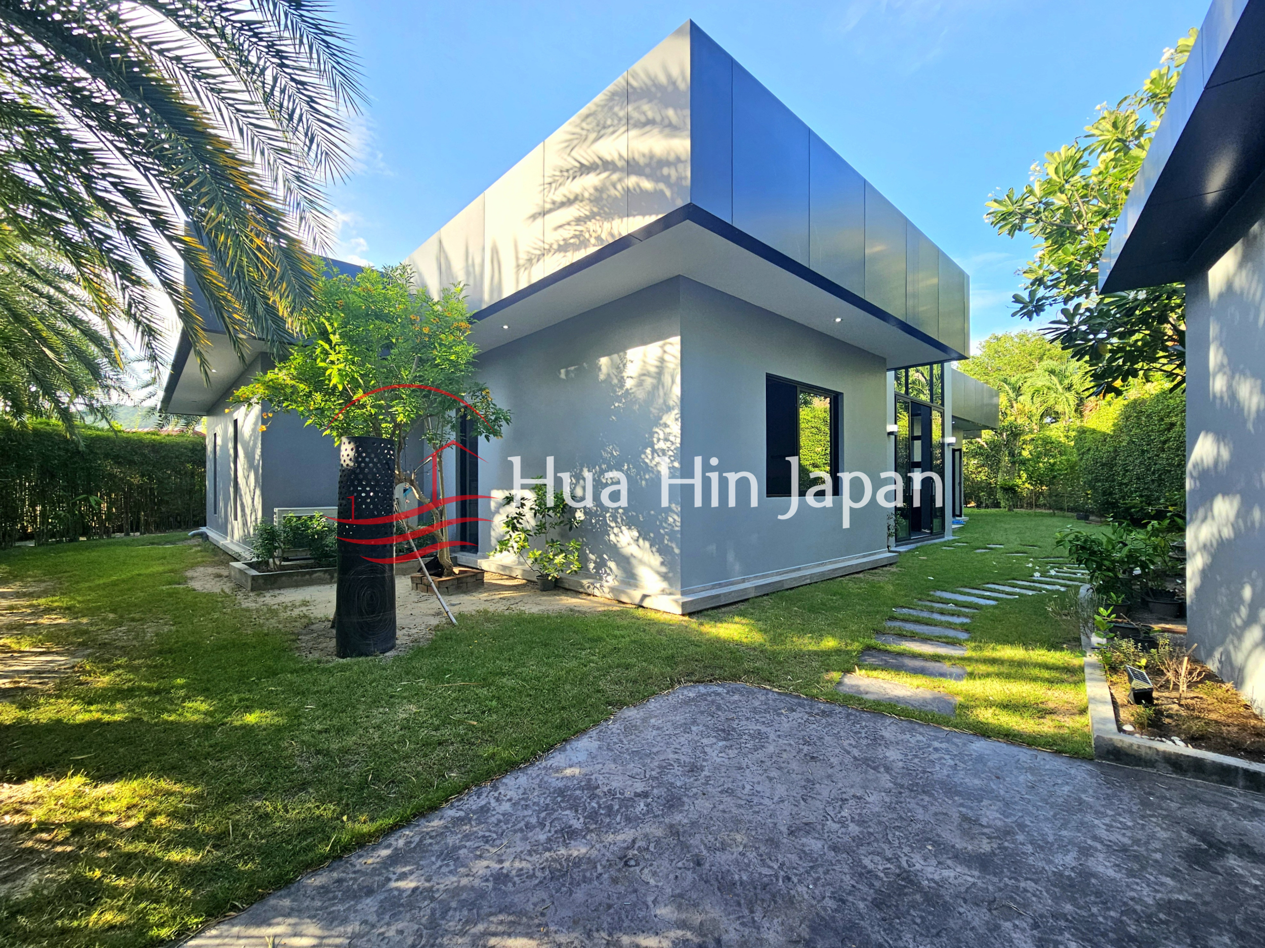 Modern villa exterior with clean architectural lines, landscaped garden, tropical palm trees, and a stepping-stone pathway