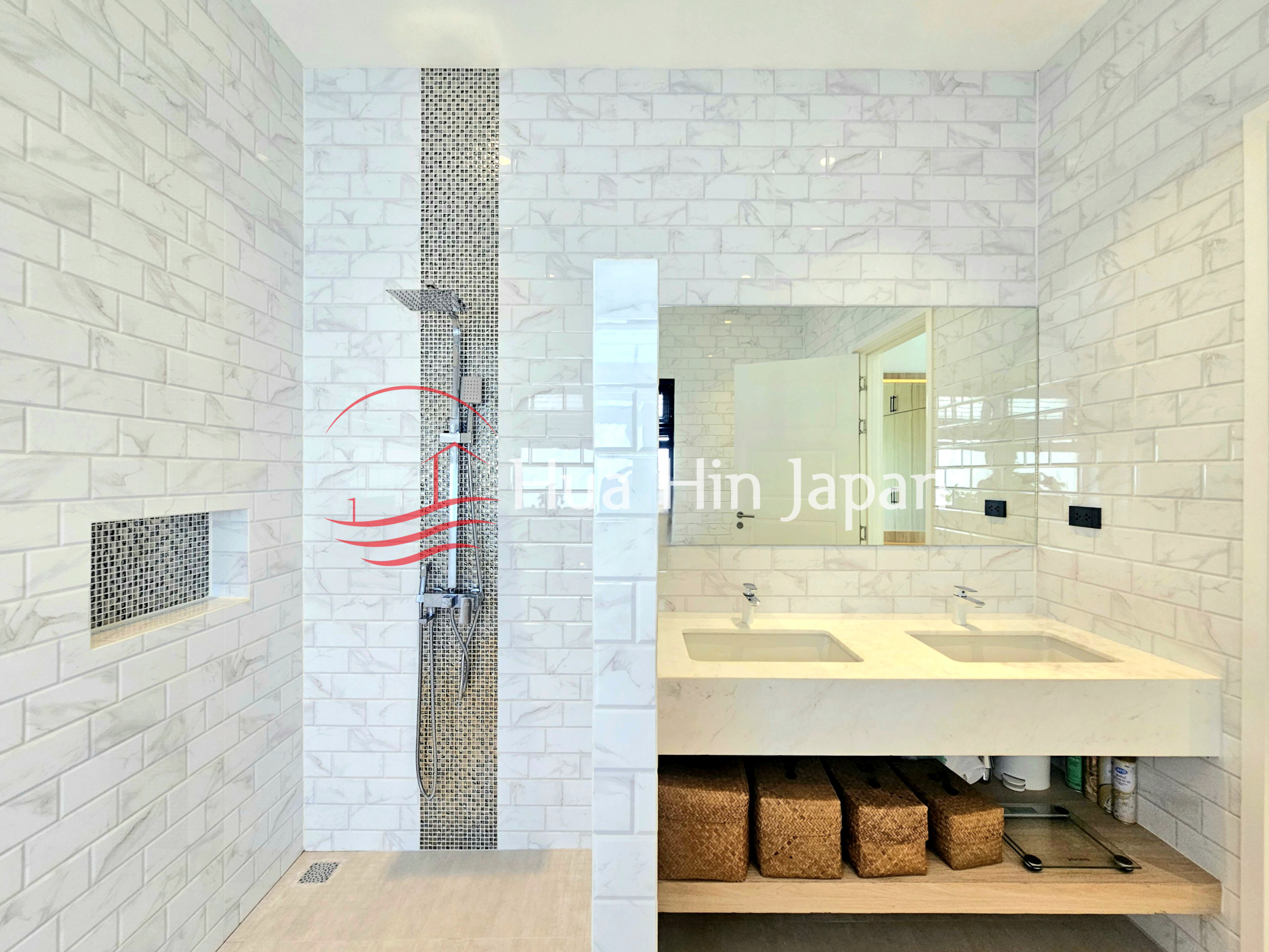Modern bathroom with a walk-in shower, double vanity, and white marble-style tile walls