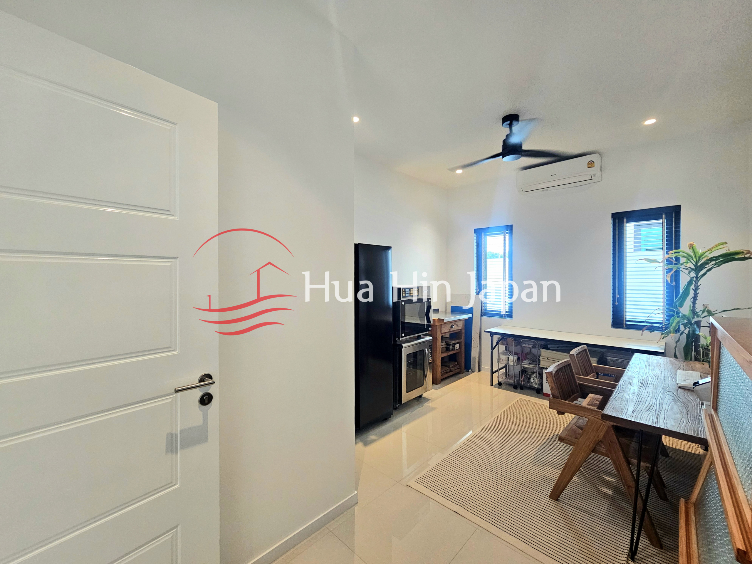 Bright modern dining and living area with wooden dining table, chairs, TV, ceiling fan, and air conditioner