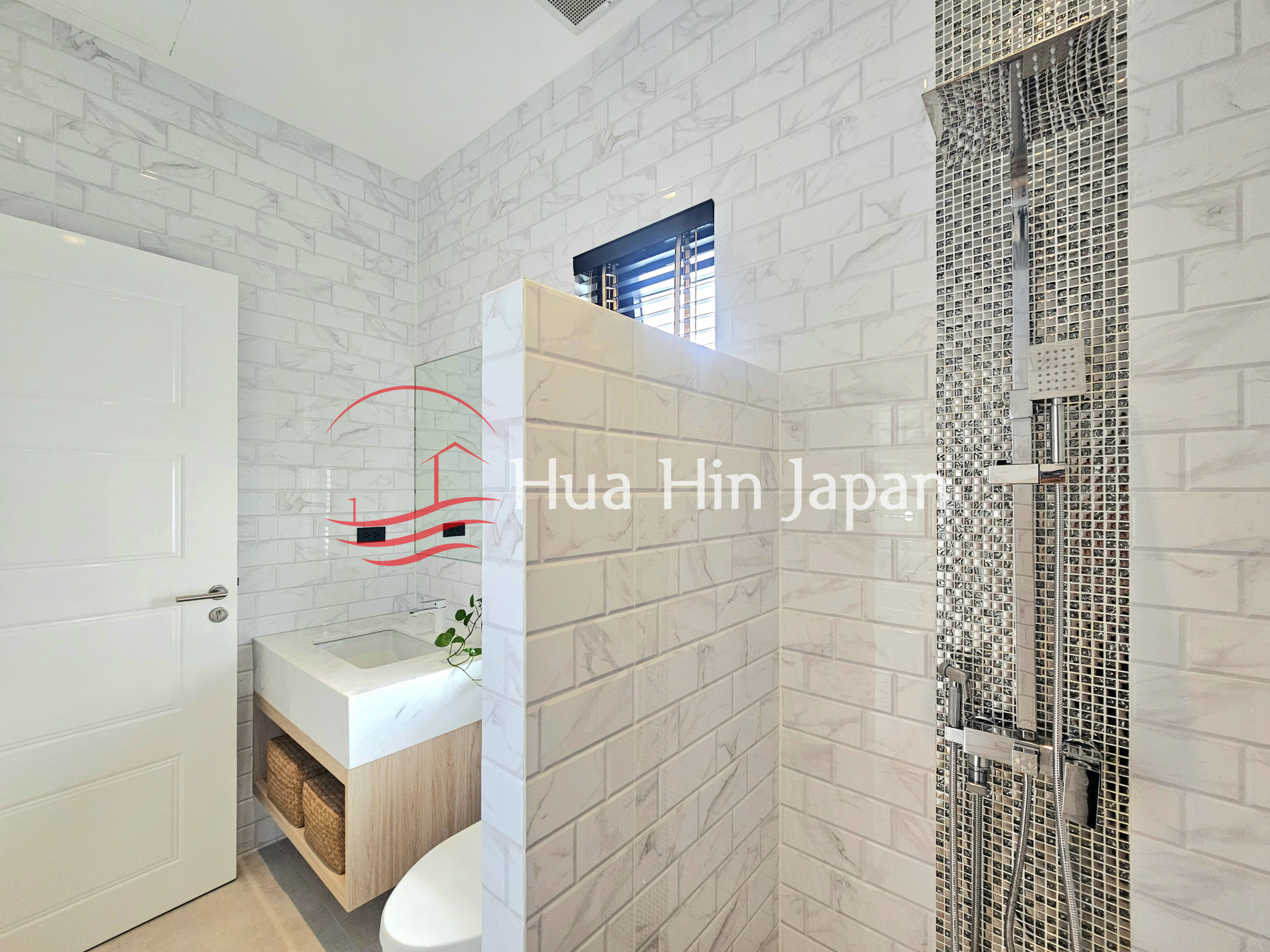 Bright modern bathroom with white brick-style wall tiles, a walk-in shower, and a floating vanity