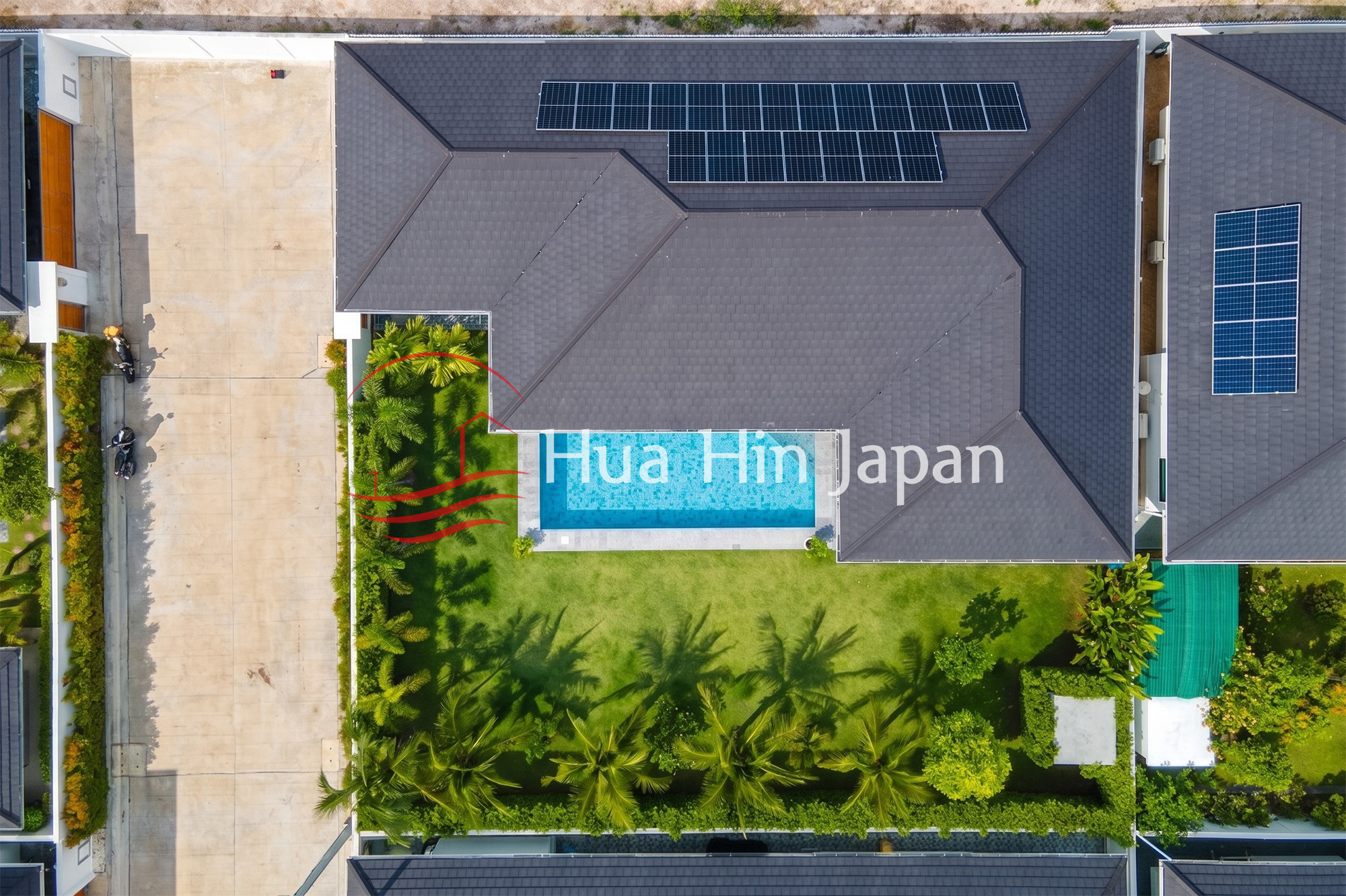 Top-down aerial view of a modern villa with a private swimming pool, landscaped garden, and solar panels