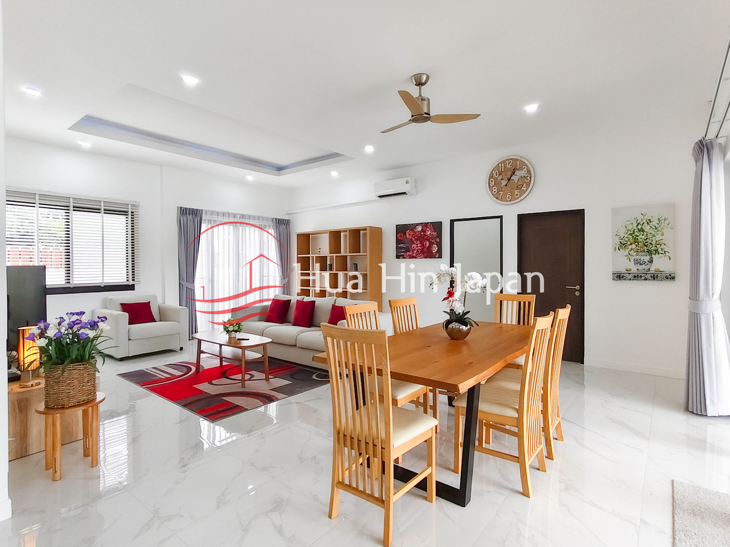 Spacious modern living and dining room with sofa, dining table, curtains, and ceiling fan