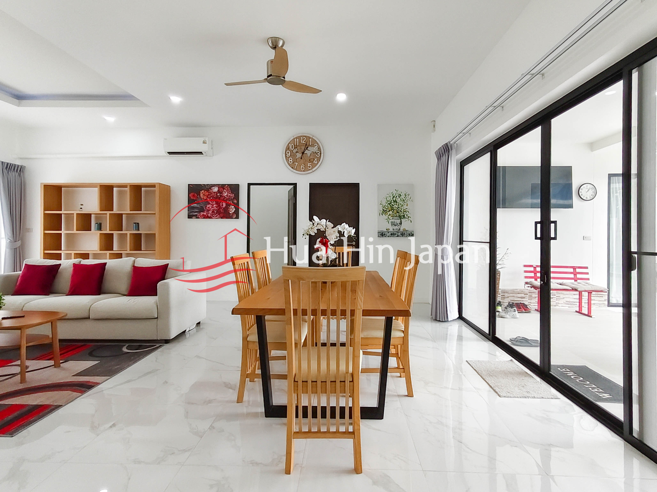 Modern dining area with wooden table, chairs, ceiling fan, and large glass doors