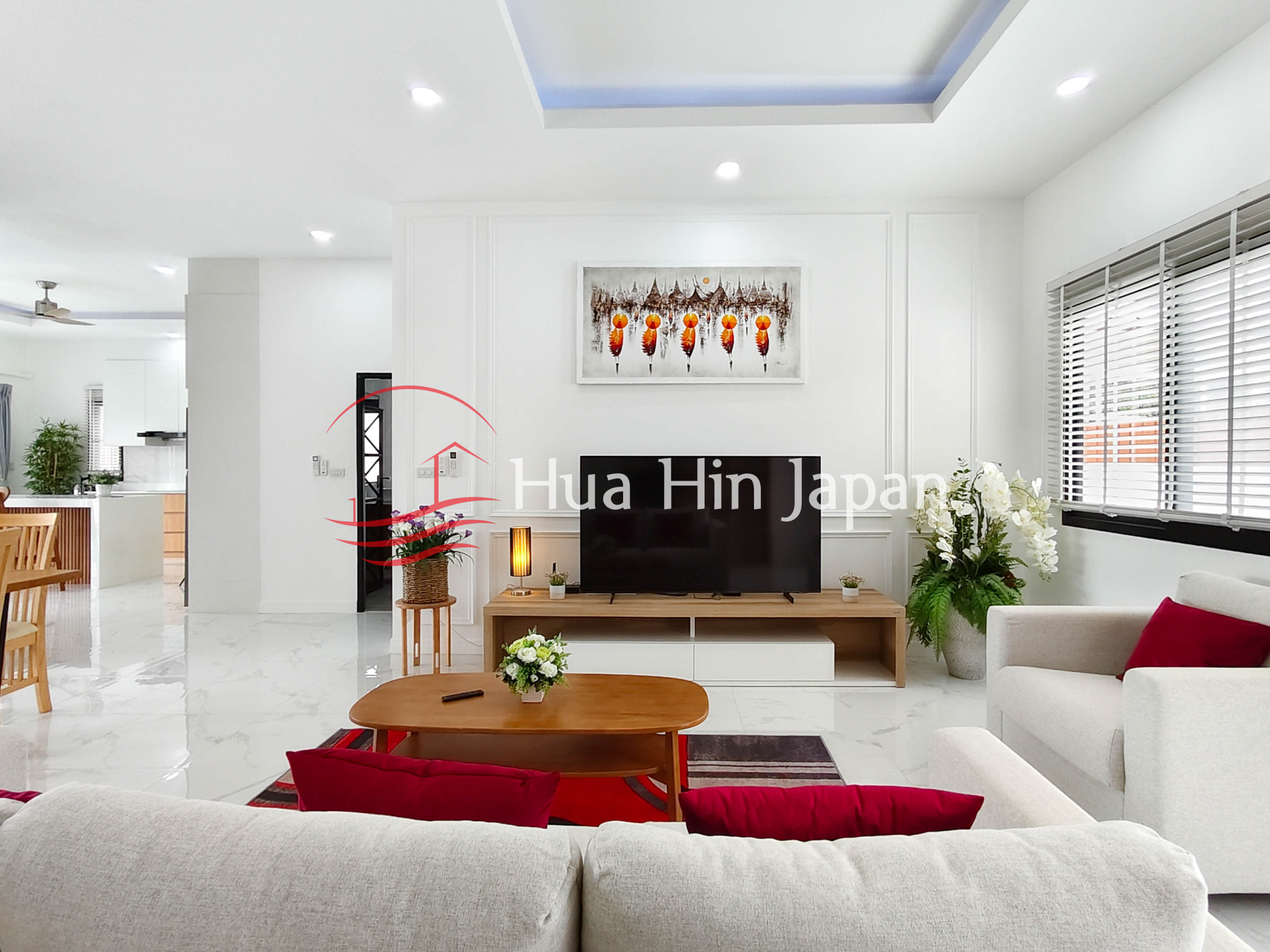 Bright modern living room with sofa, wall artwork, recessed ceiling, and curtains