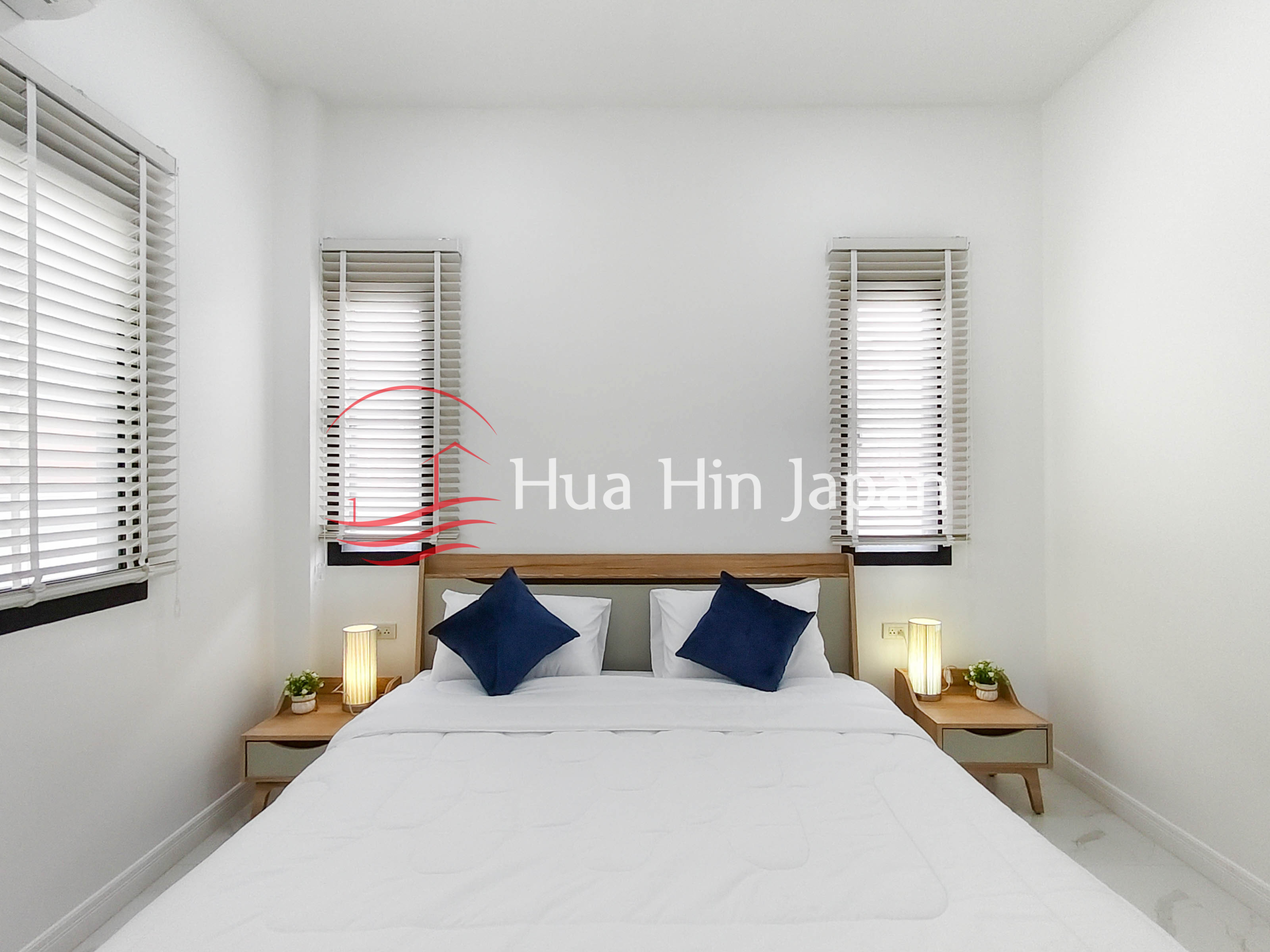 Bright modern bedroom with large window blinds, bed, white walls, and ceiling lights