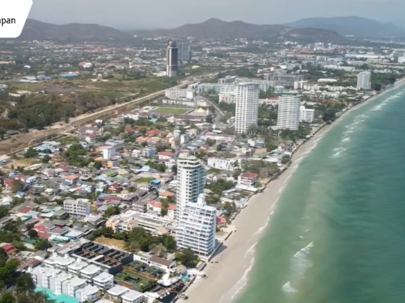 Aerial view of Hua Hin beach at sunset, showing turquoise water, sandy shores, and beachfront resorts near Khao Takiab hill in Thailand.